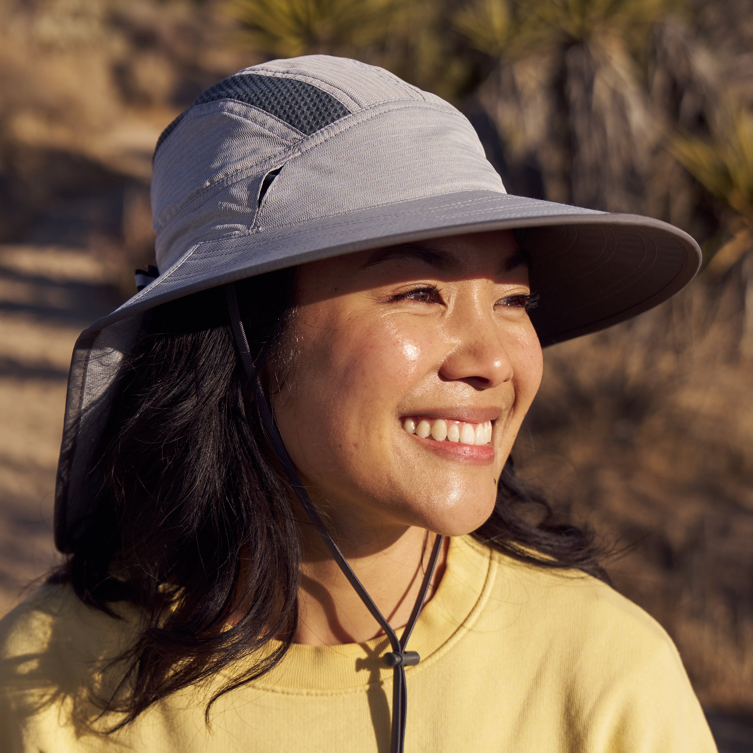 Woman wearing a Sunday Afternoons Ultra Adventure Hat in the pumice color, in a nature setting